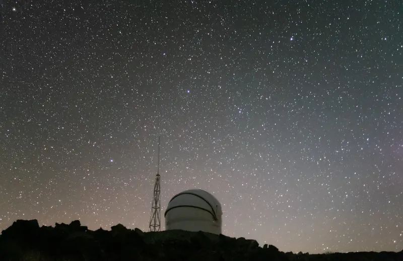 A telescope dome under a starry sky